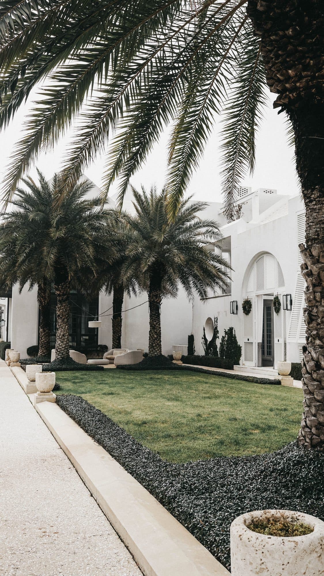 Palm-lined courtyard entrance to a home on 30A